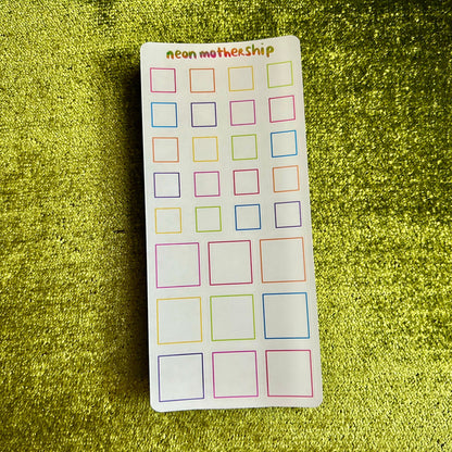 Sheet of colorful square stickers on a green textured background