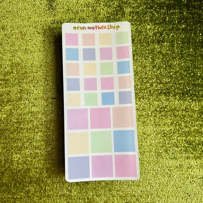 sticker sheet with pastel square stickers on a green textured background