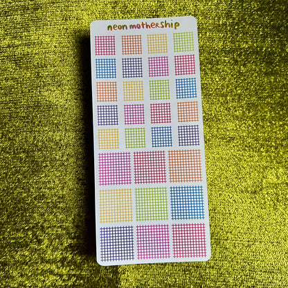 sticker sheet with grid patterns on a green textured surface