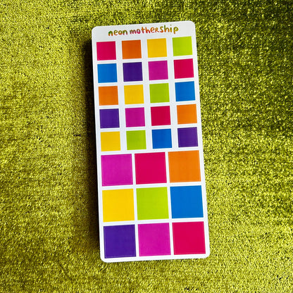 Color swatch sticker with squares in various colors on a green textured background