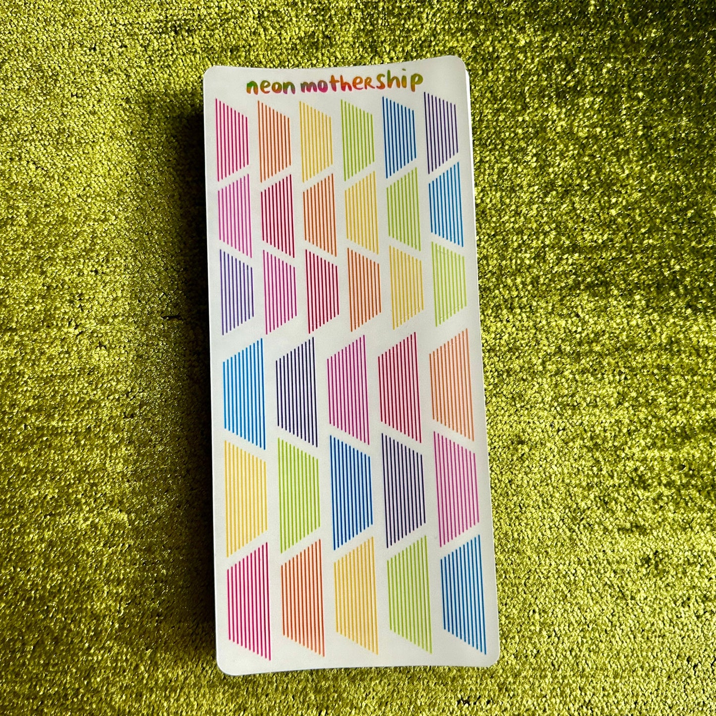 Colorful geometric patterned stickers on a green textured background