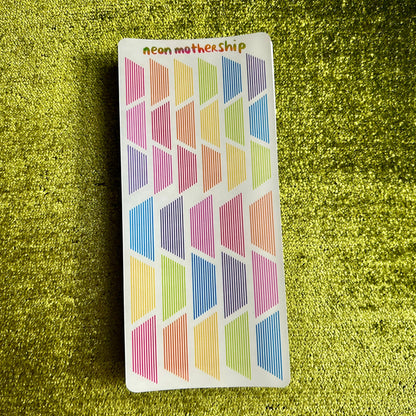 Colorful geometric patterned stickers on a green textured background