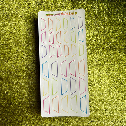 Sheet of colorful geometric stickers on a green glittery background