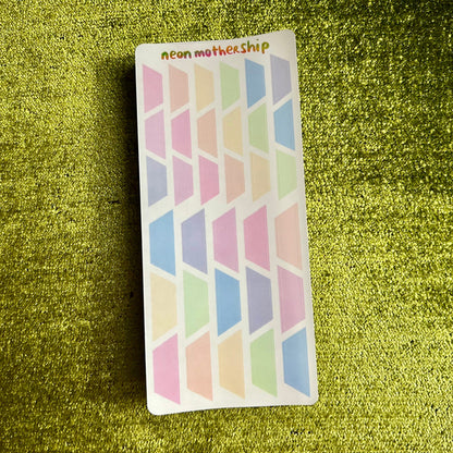 Colorful geometric patterned stickers on a green textured surface