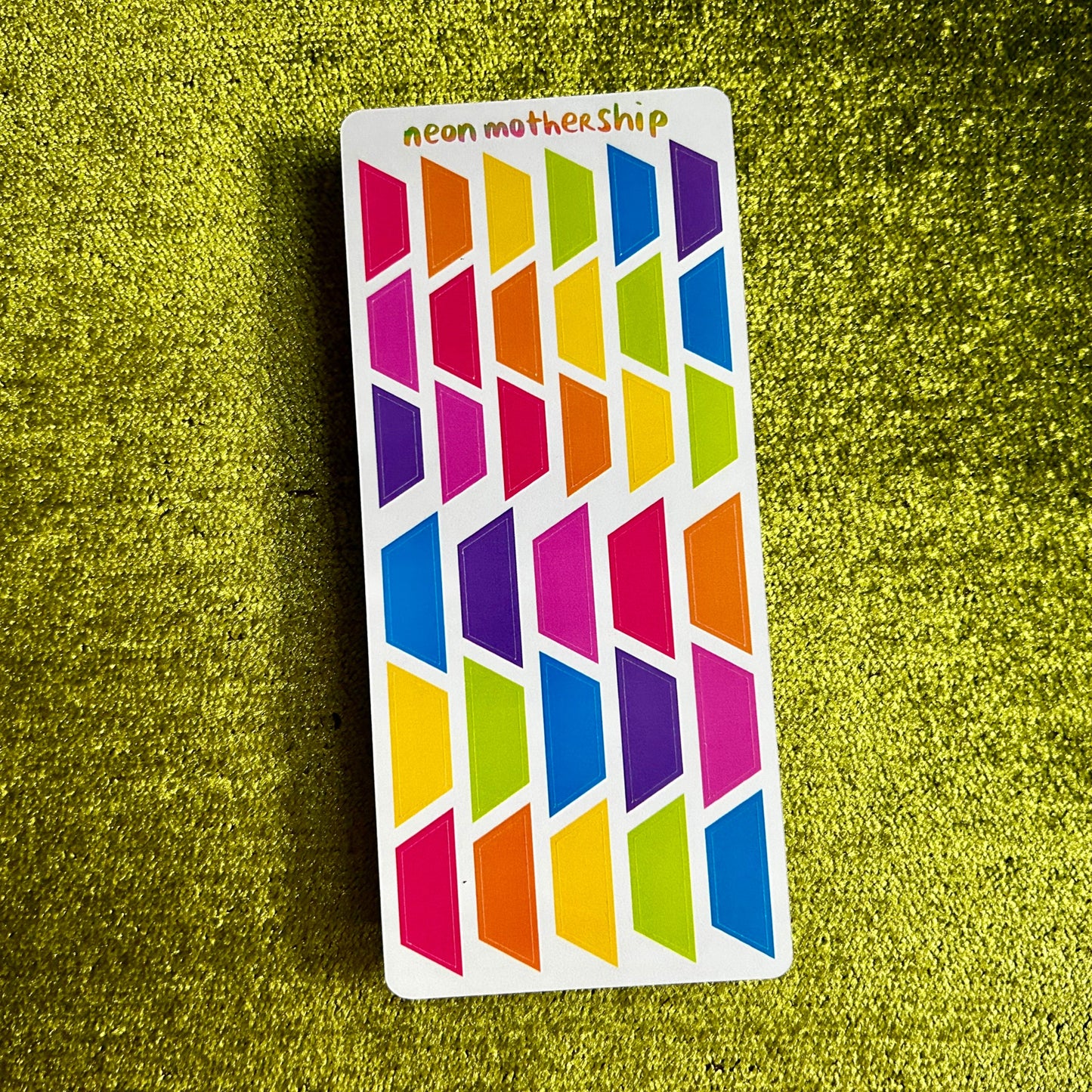 Colorful geometric patterned stickers on a green textured surface