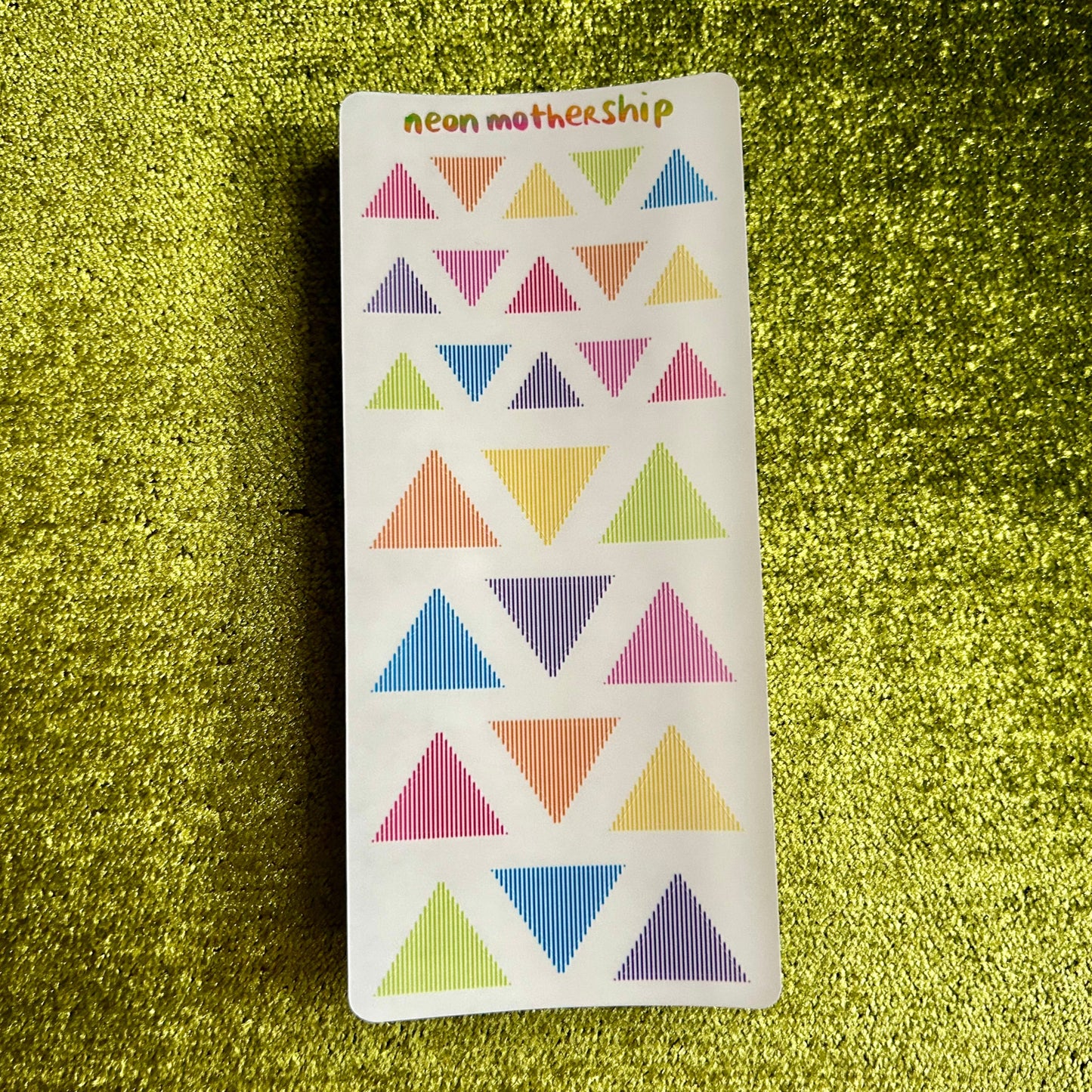 Sticker with colorful triangle pattern on a green textured background