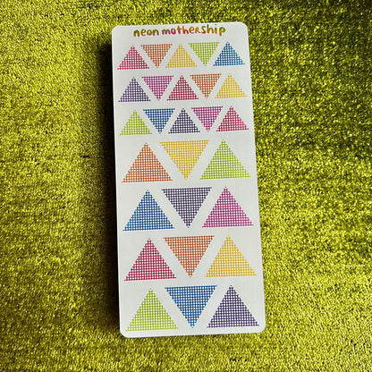 Card with colorful triangle stickers on a green textured surface
